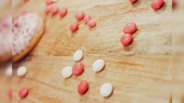 Tatlılarla süslenmiş pembe çörekler. Makro ve kaydırma atışı. Tatlı, jöleli tatlılar. Fırın ve yemek konsepti. Çeşitli renkli çörekler. Çikolata, pembe, mavi çörekler 4K, UHD.