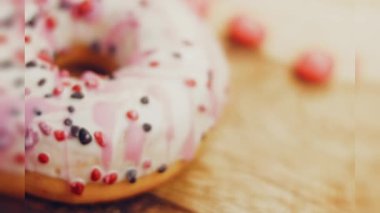 Tatlılarla süslenmiş pembe çörekler. Makro ve kaydırma atışı. Tatlı, jöleli tatlılar. Fırın ve yemek konsepti. Çeşitli renkli çörekler. Çikolata, pembe, mavi çörekler 4K, UHD.