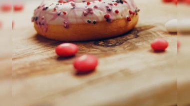 Tatlılarla süslenmiş pembe çörekler. Makro ve kaydırma atışı. Tatlı, jöleli tatlılar. Fırın ve yemek konsepti. Çeşitli renkli çörekler. Çikolata, pembe, mavi çörekler 4K, UHD.