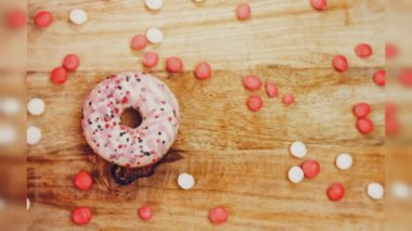 Tatlılarla süslenmiş pembe çörekler. Makro ve kaydırma atışı. Tatlı, jöleli tatlılar. Fırın ve yemek konsepti. Çeşitli renkli çörekler. Çikolata, pembe, mavi çörekler 4K, UHD.