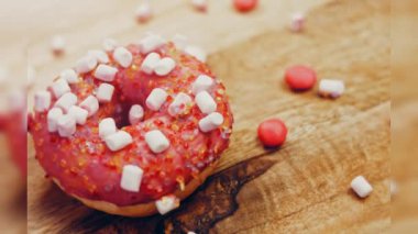 Marshmello ile süslenmiş pembe çörekler. Makro ve kaydırma atışı. Fırın ve yemek konsepti. Çeşitli renkli çörekler. Çikolata, pembe, mavi çörekler 4K, UHD.