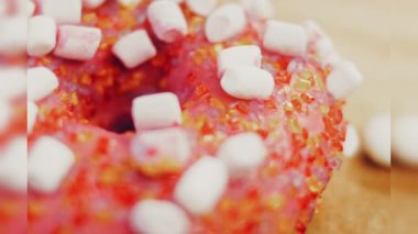 Marshmello ile süslenmiş pembe çörekler. Makro ve kaydırma atışı. Fırın ve yemek konsepti. Çeşitli renkli çörekler. Çikolata, pembe, mavi çörekler 4K, UHD.