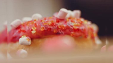Marshmello ile süslenmiş pembe çörekler. Makro ve kaydırma atışı. Fırın ve yemek konsepti. Çeşitli renkli çörekler. Çikolata, pembe, mavi çörekler 4K, UHD.