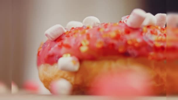 분홍색 도넛은 마시멜로로 장식되어 있습니다 매크로와 슬라이더 음식의 색상의 초콜릿 — 비디오