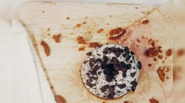 Oeo bisküvileriyle süslenmiş çikolatalı çörekler. Donutlar doğal çikolatayla süslenmiş bir kağıdın üzerinde. Makro ve kaydırma atışı. Fırın ve yemek konsepti. Çeşitli renkli çörekler. Çikolata.