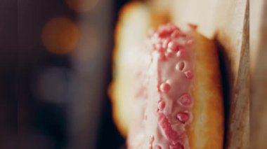 Çikolata, marşmelov ve retro pişirme tepsisindeki şekerli çörekler. Donutlar doğal çikolatayla süslenmiş bir kağıdın üzerinde. Makro ve kaydırma atışı. Çeşitli renkli çörekler. Çikolata, pembe, mavi çörekler