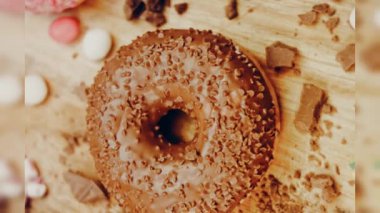 Çikolata, marşmelov ve retro pişirme tepsisindeki şekerli çörekler. Donutlar doğal çikolatayla süslenmiş bir kağıdın üzerinde. Makro ve kaydırma atışı. Çeşitli renkli çörekler. Çikolata, pembe, mavi çörekler