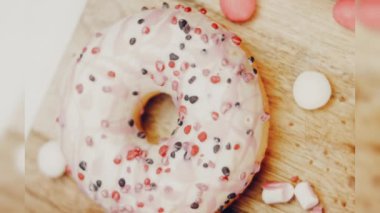 Çikolata, marşmelov ve retro pişirme tepsisindeki şekerli çörekler. Donutlar doğal çikolatayla süslenmiş bir kağıdın üzerinde. Makro ve kaydırma atışı. Çeşitli renkli çörekler. Çikolata, pembe, mavi çörekler