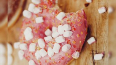 Kız hediyeler arasından seçiyor, parmağını işaret ediyor. Çikolata, marşmelov ve retro pişirme tepsisindeki şekerli çörekler. Donutlar doğal çikolatayla süslenmiş bir kağıdın üzerinde. Makro ve kaydırıcı