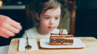 Eski usul bir pasta tepsisinde bir sürü pasta dilimi. Şef, kızların tatmasına farklı türde pasta getiriyor. Pelerinli kız pastayı sevmediğini gösteriyor..