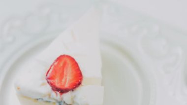 Retro tabakta limonlu cheesecake. Altın çatal ve bıçak kullan. Kız çatalla bir parça kek yiyor. Arka plandaki kız eğleniyor. Doğum gününü kutluyoruz. Yavaş çekim.