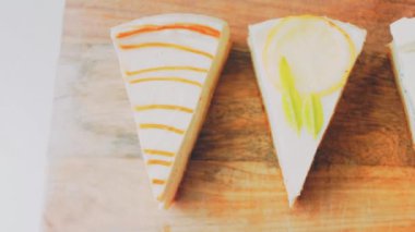 Arka arkaya dizilmiş dört çeşit cheesecake. Kaypak ve makro atış. Bir retro stil pişirme tahtası kullanılır.
