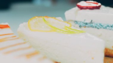 Arka arkaya dizilmiş dört çeşit cheesecake. Kaypak ve makro atış. Bir retro stil pişirme tahtası kullanılır.