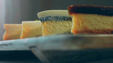 Arka arkaya dizilmiş dört çeşit cheesecake. Kaypak ve makro atış. Bir retro stil pişirme tahtası kullanılır.