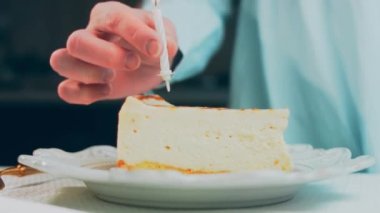 Retro tabakta limonlu cheesecake. Altın çatal ve bıçak kullan. Kız çatalla bir parça kek yiyor. Arka plandaki kız eğleniyor. Doğum gününü kutluyoruz. Yavaş çekim.