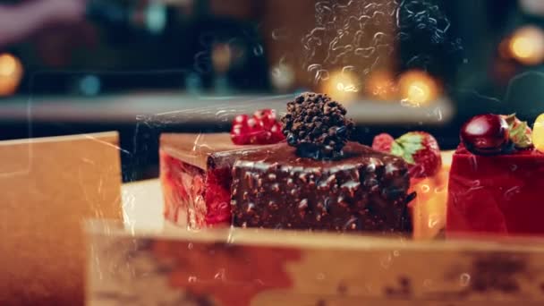 オープンボックスに白と赤のイチゴとチェリーケーキとチョコレートのいくつかのスライス マクロとスライダーの撮影 背景はレトロな雰囲気です — ストック動画