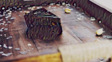 Tahta tepside altın tozuyla süslenmiş muzlu çikolatalı pasta..