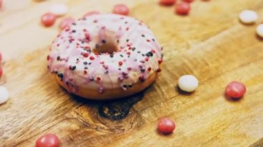 Tatlılarla süslenmiş pembe çörekler. Makro ve kaydırma atışı. Tatlı, jöleli tatlılar. Fırın ve yemek konsepti. Çeşitli renkli çörekler. Çikolata, pembe, mavi çörekler 4K, UHD.