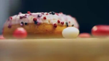 Tatlılarla süslenmiş pembe çörekler. Makro ve kaydırma atışı. Tatlı, jöleli tatlılar. Fırın ve yemek konsepti. Çeşitli renkli çörekler. Çikolata, pembe, mavi çörekler 4K, UHD.