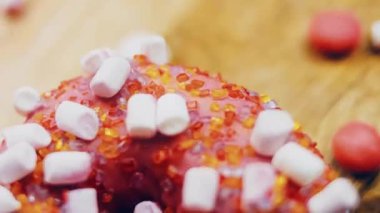 Marshmello ile süslenmiş pembe çörekler. Makro ve kaydırma atışı. Fırın ve yemek konsepti. Çeşitli renkli çörekler. Çikolata, pembe, mavi çörekler 4K, UHD.