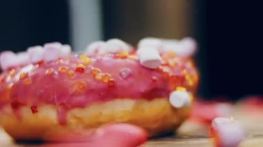 Marshmello ile süslenmiş pembe çörekler. Makro ve kaydırma atışı. Fırın ve yemek konsepti. Çeşitli renkli çörekler. Çikolata, pembe, mavi çörekler 4K, UHD.