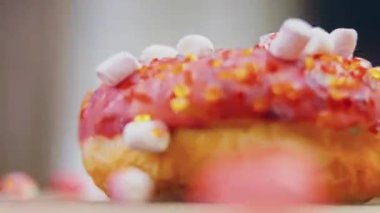 Marshmello ile süslenmiş pembe çörekler. Makro ve kaydırma atışı. Fırın ve yemek konsepti. Çeşitli renkli çörekler. Çikolata, pembe, mavi çörekler 4K, UHD.