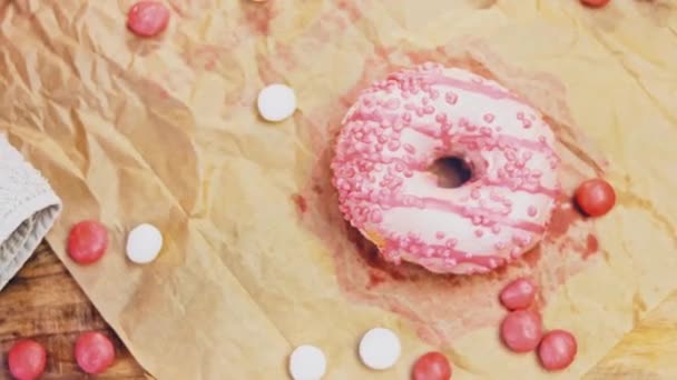 Розовые Пончики Украшенные Розовой Глазурью Пончики Клочке Бумаги Украшенном Конфетами — стоковое видео