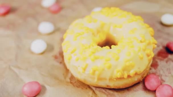 Рожеві Пончики Прикрашені Жовтим Глазур Пончики Шматку Паперу Прикрашеному Цукерками — стокове відео