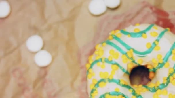 Желтые Пончики Украшенные Голубой Глазурью Пончики Клочке Бумаги Украшенном Конфетами — стоковое видео
