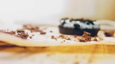 Oeo bisküvileriyle süslenmiş çikolatalı çörekler. Donutlar doğal çikolatayla süslenmiş bir kağıdın üzerinde. Makro ve kaydırma atışı. Fırın ve yemek konsepti. Çeşitli renkli çörekler. Çikolata.