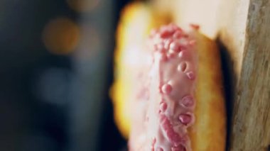 Çikolata, marşmelov ve retro pişirme tepsisindeki şekerli çörekler. Donutlar doğal çikolatayla süslenmiş bir kağıdın üzerinde. Makro ve kaydırma atışı. Çeşitli renkli çörekler. Çikolata, pembe, mavi çörekler