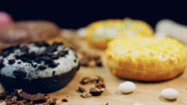 巧克力 棉花糖和糖果甜甜圈在一个复古烤盘 甜甜圈在用天然巧克力装饰的纸上 宏观和滑翔机射击 各种彩色甜甜圈 巧克力 蓝甜甜圈 — 图库视频影像