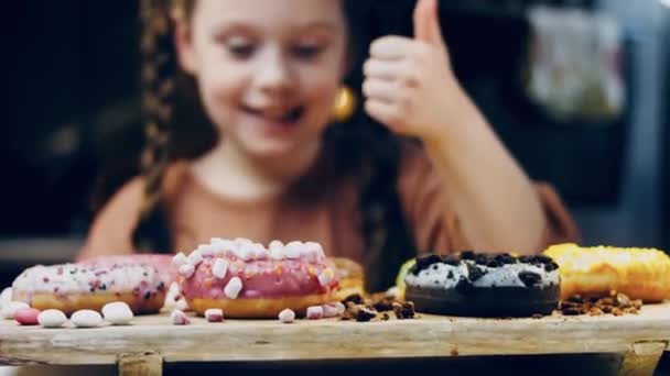 Flickan Väljer Mellan Flera Gåvor Och Pekar Finger Choklad Marshmello — Stockvideo