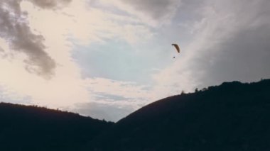 Paraglider, güneşli mavi gökyüzünün arka planında süzülüyor. Alt görünüm.