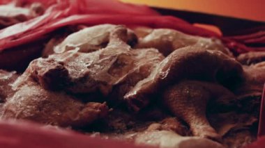 Eldivenli ellerin yakın plan görüntüsü tavuk bacağını bir kutudan ayrı plastik poşetlere paketliyor. Evde daha fazla kullanılmak üzere dondurulmuş etin süreci. Işık oynatma ile 4k video