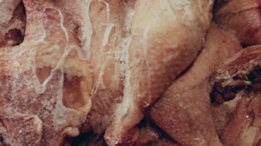 Eldivenli ellerin yakın plan görüntüsü tavuk bacağını bir kutudan ayrı plastik poşetlere paketliyor. Evde daha fazla kullanılmak üzere dondurulmuş etin süreci. Işık oynatma ile 4k video