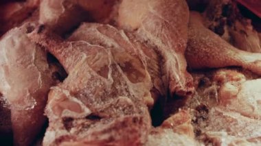 Eldivenli ellerin yakın plan görüntüsü tavuk bacağını bir kutudan ayrı plastik poşetlere paketliyor. Evde daha fazla kullanılmak üzere dondurulmuş etin süreci. Işık oynatma ile 4k video