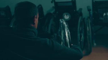 A disabled man assembles a stroller. Assembling strollers for people with disabilities in a poor country.