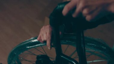 A disabled man assembles a stroller. Assembling strollers for people with disabilities in a poor country.