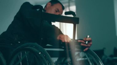 A disabled man assembles a stroller. Assembling strollers for people with disabilities in a poor country.