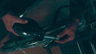 A disabled man assembles a stroller. Assembling strollers for people with disabilities in a poor country.