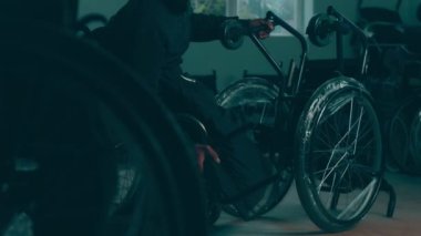 A disabled man assembles a stroller. Assembling strollers for people with disabilities in a poor country.