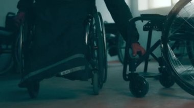 A disabled man assembles a stroller. Assembling strollers for people with disabilities in a poor country.