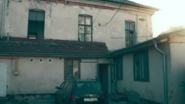 İçler acısı durumdaki çok eski bir ev. Kırılmış ve tahrip edilmiş pencereler.