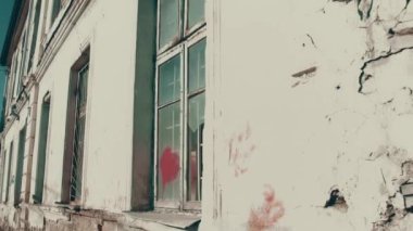 İçler acısı durumdaki çok eski bir ev. Kırılmış ve tahrip edilmiş pencereler.