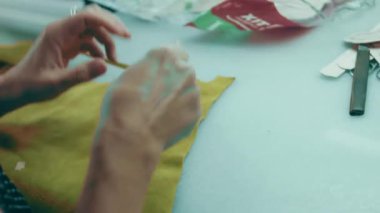 Deri atölyesinde dikiş makinesi çalışıyor. Elleri ayakkabı için deri detaylar üzerinde çalışıyor. Ayakkabı fabrikasında dikiş makinesiyle kadın eli makro çekim..