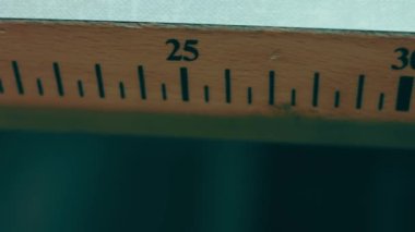 Koyu renkli ayakkabı dikmek için iplik makaraları bir rafta duruyor.