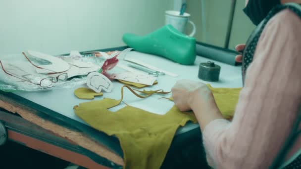 靴の革の詳細を扱う手で動作する革のワークショップでミシン 靴工場でミシンで女性の手のマクロショット — ストック動画
