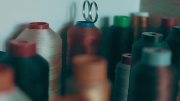 暗い色の靴を縫うための糸のスプール棚の上に立つ — ストック動画