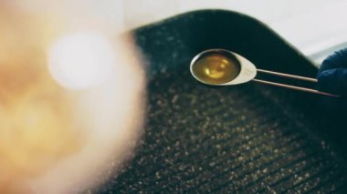 Şefin yakın çekimi, yemek pişirmek için dökme demir tava yağı ekliyor. Yavaş çekim 4K video.